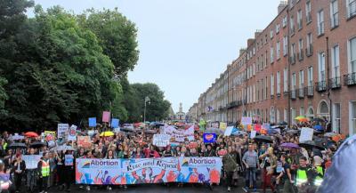 A large crowd marching down a Dublin street with banners and placards at the 2016 March for Choice