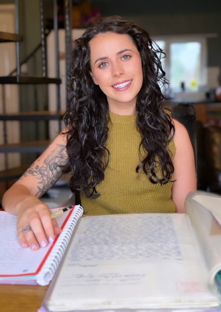 Holly Lennon seated at a table with an open notebook and documents