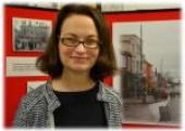 Portrait of Lorraine Bourke in front of an exhibition display